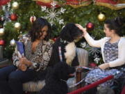 First lady Michelle Obama, sitting Bo Obama, center, and Luna Fera, 11, finishes reading &quot;Twas the Night Before Christmas&quot; to a group of children at the Children&#039;s National Health System on Dec. 14in Washington.