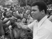 Muhammad Ali is greeted in downtown Kinshasa, Zaire, on Sept. 17, 1974. Ali was in Zaire to fight George Foreman. Ali, the magnificent heavyweight champion whose fast fists and irrepressible personality transcended sports and captivated the world, died on Friday, June 3, 2016. He was 74.