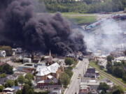 Smoke rises from burning railway cars July 6, 2013, after a derailment in downtown Lac Mégantic, Quebec, Canada.  An insurance expert said that damage estimates for that disaster are at about $3 billion, and that the railroad company involved has filed for bankruptcy because it didn&#039;t have enough insurance to pay the claims.