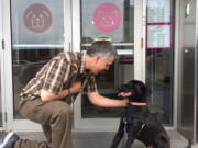 Mike Rueb of the Bideawee animal shelter in New York pets Clay, a 9-month-old black lab mix, last month outside the shelter in New York.