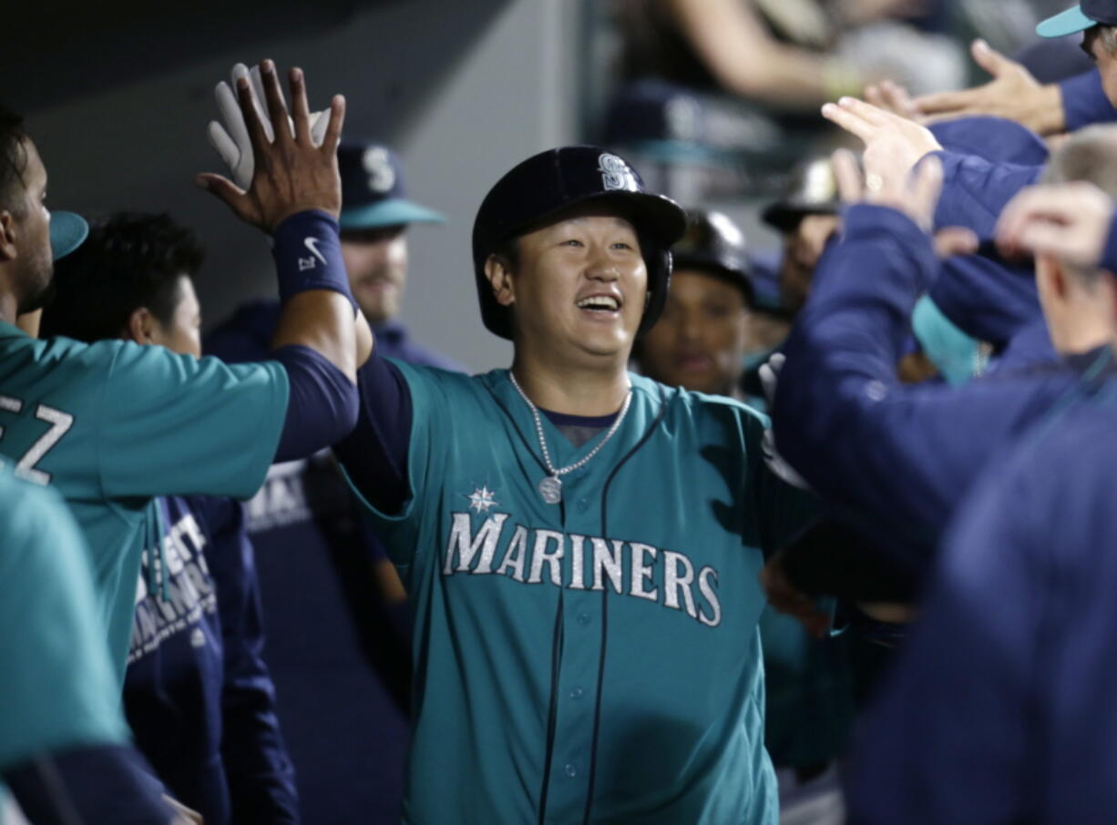 Seattle Mariners&#039; Dae-Ho Lee celebrates in the dugout after hitting a three-run home run off Texas Rangers&#039; Derek Holland during fourth inning of a baseball game Friday, June 10, 2016, in Seattle. This is his second home run of the night.