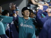 Seattle Mariners&#039; Dae-Ho Lee celebrates in the dugout after hitting a three-run home run off Texas Rangers&#039; Derek Holland during fourth inning of a baseball game Friday, June 10, 2016, in Seattle. This is his second home run of the night.