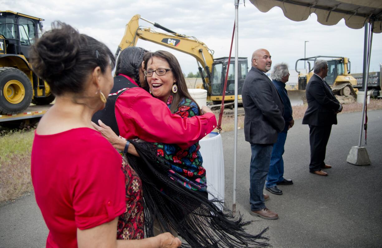 In this June 8, 2016 photo, Spokane Tribal Business Council chair Carol Evans, center, hugs council member Dave BrownEagle after the celebration of the tribe getting final approval from Gov. Jay Inslee for the tribe's long-planned casino at the corner of Craig Rd. and Highway 2 in Spokane, Wash. At far left is Norah RedFox BrownEagle, David BrownEagle's wife. Standing at right are council members Greg Abrahamson, third from right, Glenn Ford, second from right, and Kanny Kieffer, right.