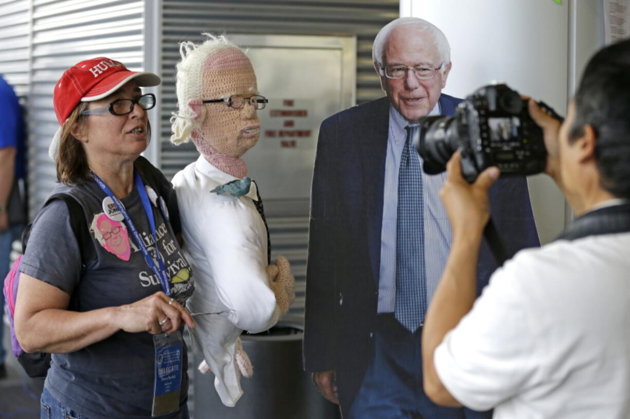 Donna Burdick, left, holds &quot;Crochet Bernie&quot; as she takes part in a video interview next to a cutout of Democratic presidential candidate Sen. Bernie Sanders, I-Vt., Friday, June 17, 2016, at the Washington state Democratic Convention in Tacoma, Wash. State Democrats are scheduled to meet through Sunday to pass a party platform and finish electing delegates to the national convention this summer. (AP Photo/Ted S.