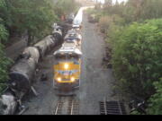 Crumpled oil tankers lie beside the railroad tracks after a fiery train derailment on June 3 that prompted evacuations from the tiny Columbia River Gorge town about 70 miles east of Portland in Mosier, Ore. Trains began running Sunday and at least eight had moved through the town of about 400 people carrying mixed goods --. Union Pacific defended its actions Monday, saying it was safe to run other trains by while crews continued to drain oil from the crashed tankers.