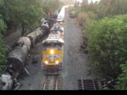 This aerial video image taken from a drone shows crumpled oil tankers lying beside the railroad tracks after a fiery train derailment on June 3 that prompted evacuations from the tiny Columbia River Gorge town about 70 miles east of Portland, on Monday, June 6, 2016, in Mosier, Ore. Trains began running Sunday and at least eight had moved through the town of about 400 people carrying mixed goods - but no crude oil - by Monday. Union Pacific defended its actions Monday, saying it was safe to run other trains by while crews continued to drain oil from the crashed tankers.