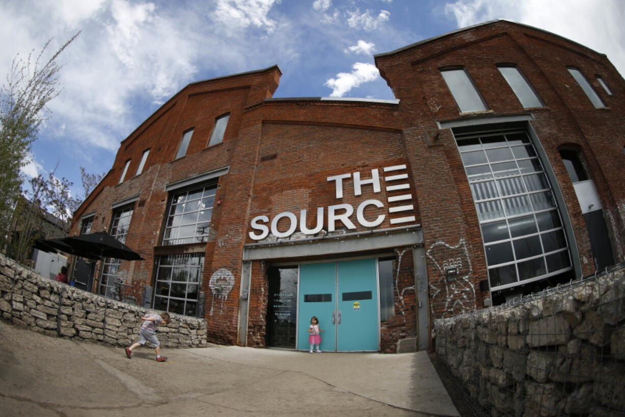 In this photograph taken with a fisheye lens, a pair of children head for the entrance of The Source, a restaurant and food shop complex along Brighton Boulevard in Denver.