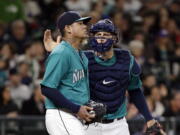 Seattle Mariners catcher Chris Iannetta, right, gives a pat to starting pitcher Felix Hernandez after a play during the third inning of a baseball game against the Minnesota Twins on Friday, May 27, 2016, in Seattle. Hernandez gave up five runs in the inning.