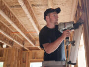 Robby Wilson works with a nail gun at an apartment construction site in downtown Vancouver.