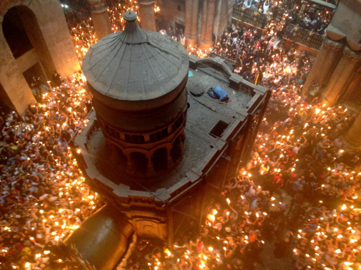 The faithful from the Eastern Orthodox churches gather for the annual Holy Fire ceremony inside the Church of the Holy Sepulchre on April 30. The domed chapel in the center of the rotunda is called the Holy Edicule and is built above the site where the faithful believe Jesus was buried in a tomb cut from the rock.