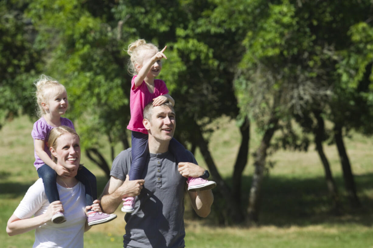 Kelsey and Kyle Potter walk with their twin daughters Emmy, left, and Quinn at the soon-to-be-built Sorenson Neighborhood Park outside Vancouver on Thursday. The park is one of two neighborhood parks Clark County is building this summer to provide recreation within walking or biking distance to residents.