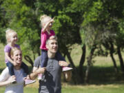 Kelsey and Kyle Potter walk with their twin daughters Emmy, left, and Quinn at the soon-to-be-built Sorenson Neighborhood Park outside Vancouver on Thursday. The park is one of two neighborhood parks Clark County is building this summer to provide recreation within walking or biking distance to residents.