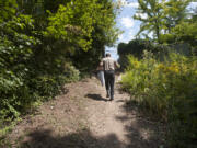 Contractor Art Rojsza walks along the trail at Wintler Park while holding plans for a new set of stairs he&#039;s building.