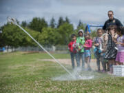 Participants in the Police Activities League summer camp watch a rocket blast off Friday at Orchards Elementary School.