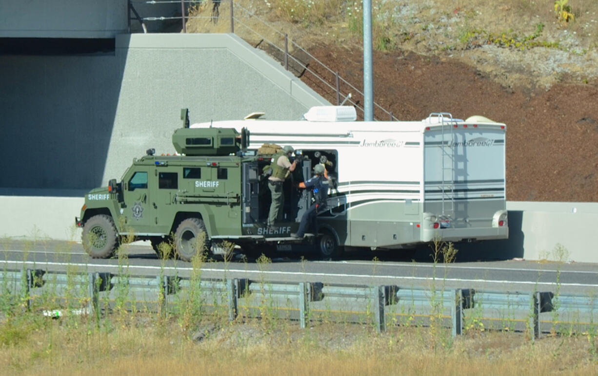 SWAT team members use an armored vehicle while investigating a stolen RV on northbound Interstate 205 on Saturday. The investigation led to a 2.5-hour freeway closure.