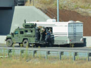 SWAT team members use an armored vehicle while investigating a stolen RV on northbound Interstate 205 on Saturday. The investigation led to a 2.5-hour freeway closure.