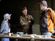 Living History Group NorthWest member Dirk deBroekert, center, speaks with  military veteran Mike Hansen of San Antonio, Texas, right, and his granddaughter Scarlett Reeder, 9, of Vancouver in the first aid tent at the WWII Encampment display at Fort Vancouver on Saturday.