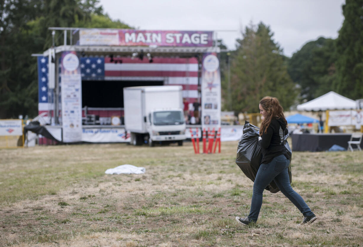 Woodland High School dance team member Jade Nosler, 14, helps with cleanup efforts Tuesday following Fourth of July festivities at the Fort Vancouver National Historic Site.