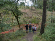 Talon Mitchell, 12, of Washougal, left, stands Camas Lily Loop Trail in Lacamas Lake Regional Park and looks onto lands that have been cleared for the Windust subdivision with his mom, Kara Morrison, and his siblings, Hayden Mitchell, 9, and Opal Mitchell, 7, in late June.