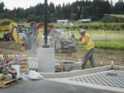 Chris Milton uses a diamond blade to cut a concrete paver at the 78th Street Heritage Farm earlier this month. The parking lot will test several types of paving surfaces that allow rainwater to permeate into the ground, avoiding runoff.