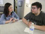 Marcela Navarro, human resource generalist at Cadet Heat, talks Wednesday with material handler, DeVonte Calvin, at Cadet Manufacturing in Vancouver.