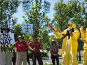 Tara Herberger wore a hazmat suit and carried an oil-stained wolf stuffed animal during a protest over the proposed oil terminal on the final day of adjudication hearings Friday at Clark College Technical Center. With the trial-like hearings concluded, the Energy Facility Site Evaluation Council will issue a recommendation to the governor, possibly later this year, whether to approve or deny the Vancouver Energy terminal project.