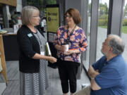 Executive Director Amelia Shelley, left, chats with Branch Manager Jackie Spurlock, center, and Mike Spurlock as people celebrate the fifth anniversary of the downtown Vancouver Community Library.