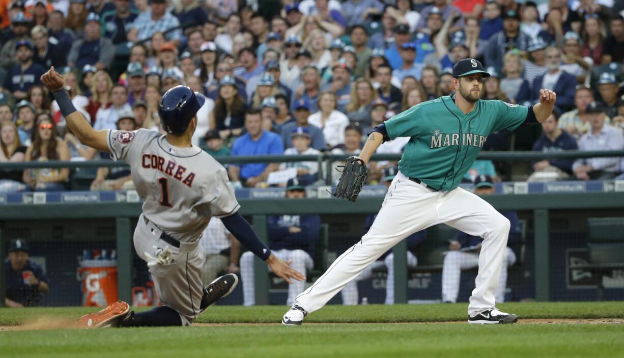 Houston Astros' Carlos Correa slides into home to score on a wild pitch by Seattle Mariners starting pitcher James Paxton, right, during the fifth inning of a baseball game Friday, July 15, 2016, in Seattle. (AP Photo/Ted S.