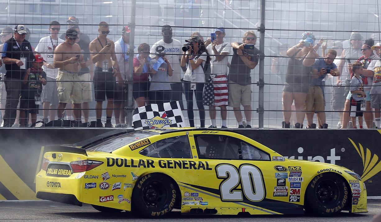 NASCAR driver Matt Kenseth drives the checkered flag past fans after winning the New Hampshire 301 auto race at New Hampshire Motor Speedway Sunday, July 17, 2016, in Loudon, N.H.