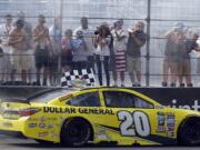 NASCAR driver Matt Kenseth drives the checkered flag past fans after winning the New Hampshire 301 auto race at New Hampshire Motor Speedway Sunday, July 17, 2016, in Loudon, N.H.