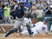 Chicago Cubs' David Ross, right, scores past Seattle Mariners catcher Chris Iannetta on a single by Chris Coghlan as Iannetta tries to get Chris Coghlan at second during the second inning of a baseball game Friday, July 29, 2016, in Chicago. Javier Baez also scored on the play.