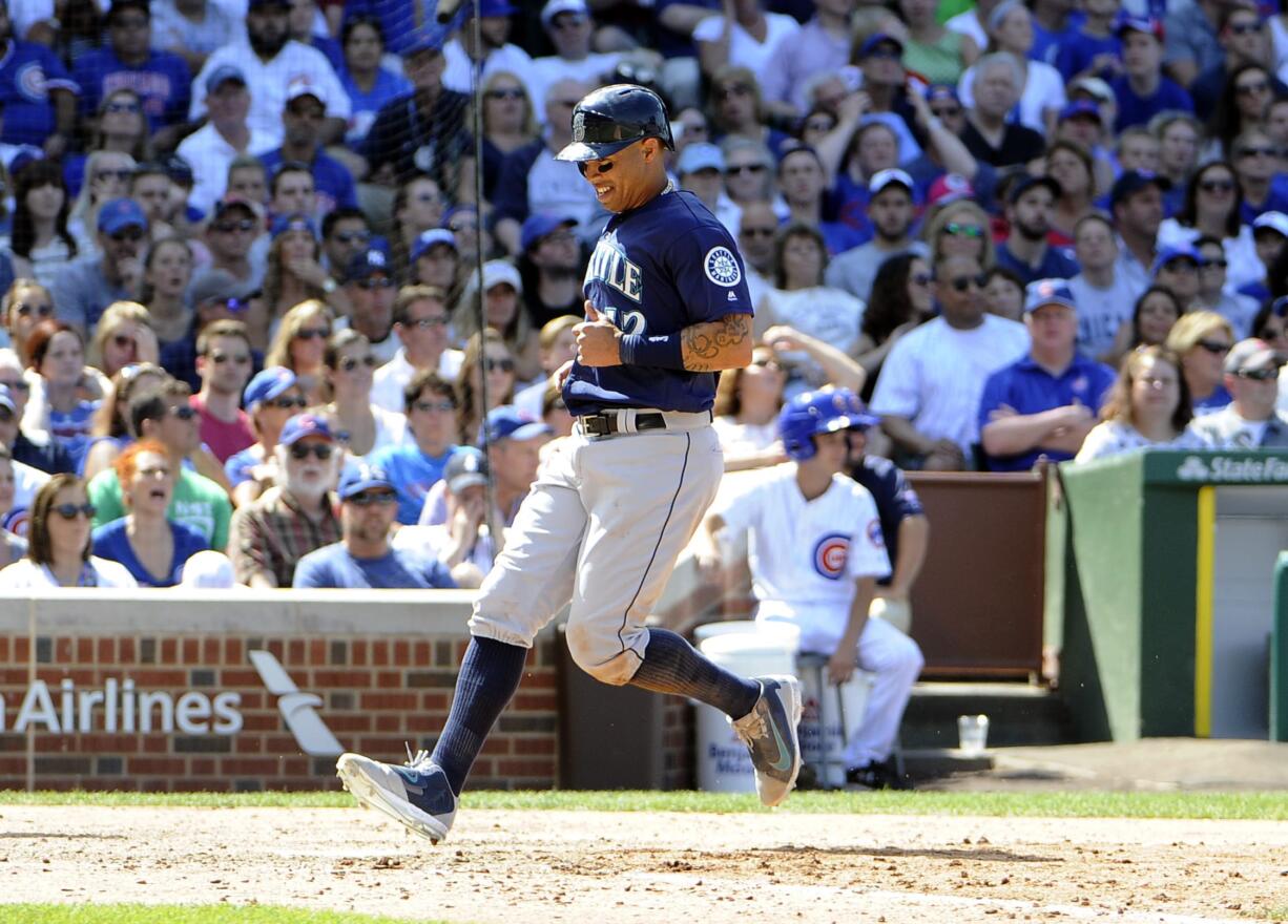 Seattle Mariners' Leonys Martin (12) crosses home plate as he scores on a wild pitch thrown by Chicago Cubs relief pitcher Aroldis Chapman (54) during the eighth inning of an interleague baseball game, Saturday, July 30, 2016, in Chicago.