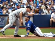 Toronto Blue Jays' Josh Thole, right, is safe at third base as Seattle Mariners Kyle Seager is late with the tag during the sixth inning of a baseball game in Toronto, Sunday, July 24, 2016.