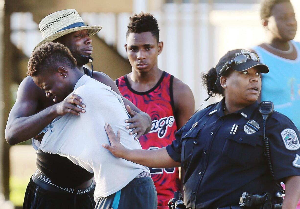 People embrace after a fatal shooting at Club Blu in Fort Myers, Fla., Monday, July 25, 2016.