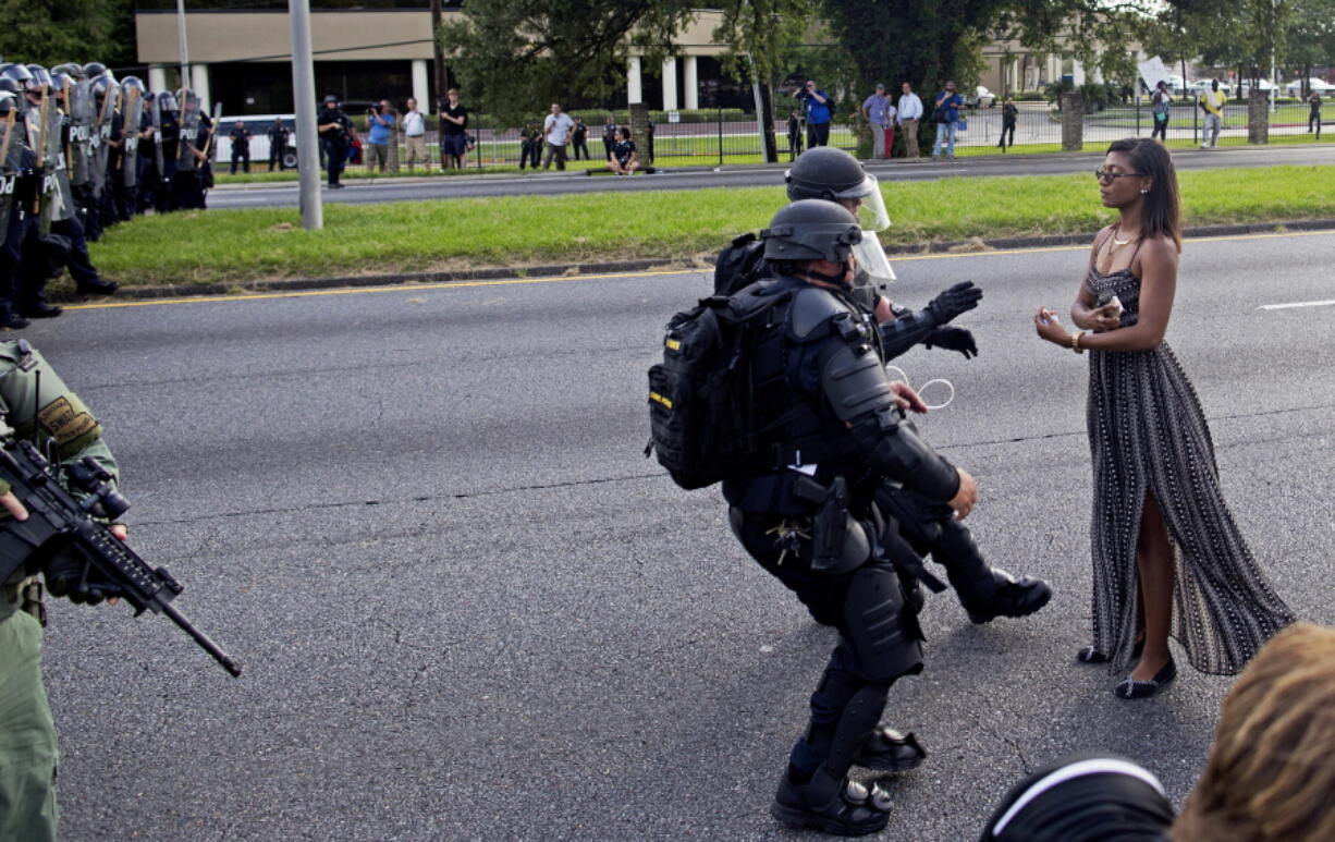 A protester is grabbed by police officers in riot gear after she refused to leave the motor way in front of the the Baton Rouge Police Department Headquarters in Baton Rouge, La. Police made nearly 200 arrests in Louisiana&#039;s capital city during weekend protests around the country in which people angry over police killings of young black men sought to block some major interstates.