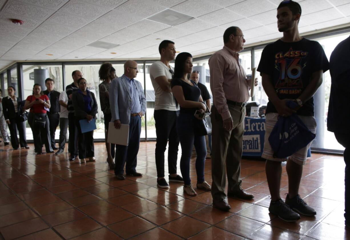 People stand in line Tuesday to register for a job fair, in Miami Lakes, Fla. On Friday, the Labor Department reports on state unemployment rates for June.