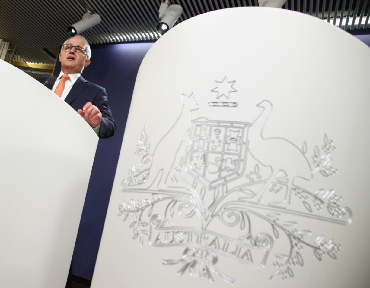 Australian Prime Minister Malcolm Turnbull speaks at the government offices in Sydney, Sunday, July 10, 2016. Turnbull said that his conservative coalition government was re-elected for a second three-year term, after a chaotic national election that left the country in a state of political paralysis for more than a week while officials scrambled to sort out who had won the tight race. The coat of arms of Australia is seen at right.