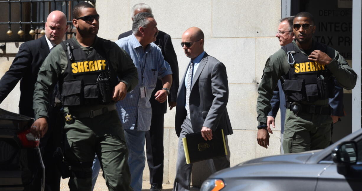 Baltimore Police Lt. Brian Rice, center, is escorted from the courthouse to a waiting car after being found not guilty on all charges related to the death of Freddy Gray on Monday in Baltimore.