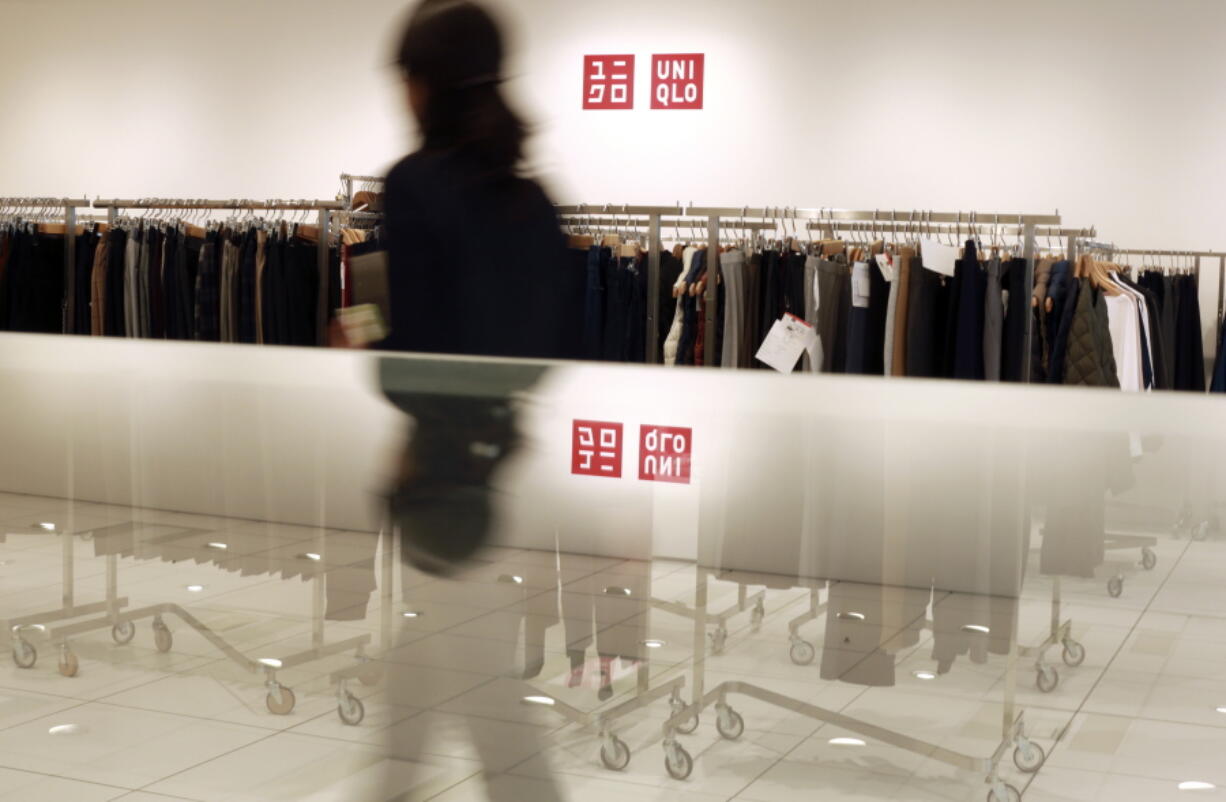 A Uniqlo staff walks among clothing stored at the press room of the corporate headquarters in Tokyo. The bloody weekend attack by Bangladeshi militants that left more than two dozen dead has also dealt a deadly blow to the country&#039;s vital garment industry.