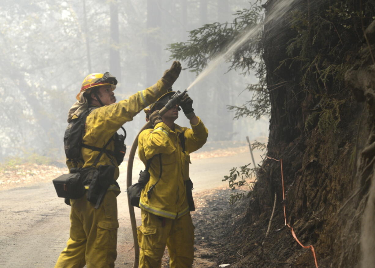 Cal Fire firefighters extinguish hotspots while fighting the Soberanes Fire in Palo Colorado Canyon on the northern Big Sur Coast on Tuesday in Big Sur, Calif. California&#039;s signature parks along the Big Sur coastline that draw thousands of daily visitors were closed Tuesday as one of the state&#039;s two major wildfires threatened the scenic region at the height of the summer tourism season.