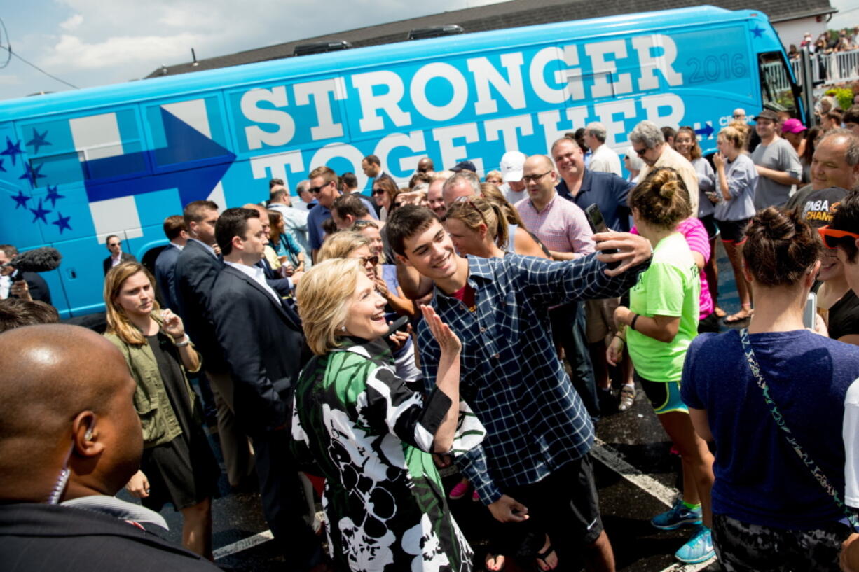 Democratic presidential candidate Hillary Clinton takes a photo with a man outside Grandma&#039;s Cheese Barn in Ashland, Ohio, Sunday. Clinton and running mate Tim Kaine are on a three day bus tour through the rust belt.