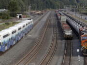 A passenger commuter train, left, passes one of two mile-long oil trains parked adjacent to the King County Airport in Seattle.