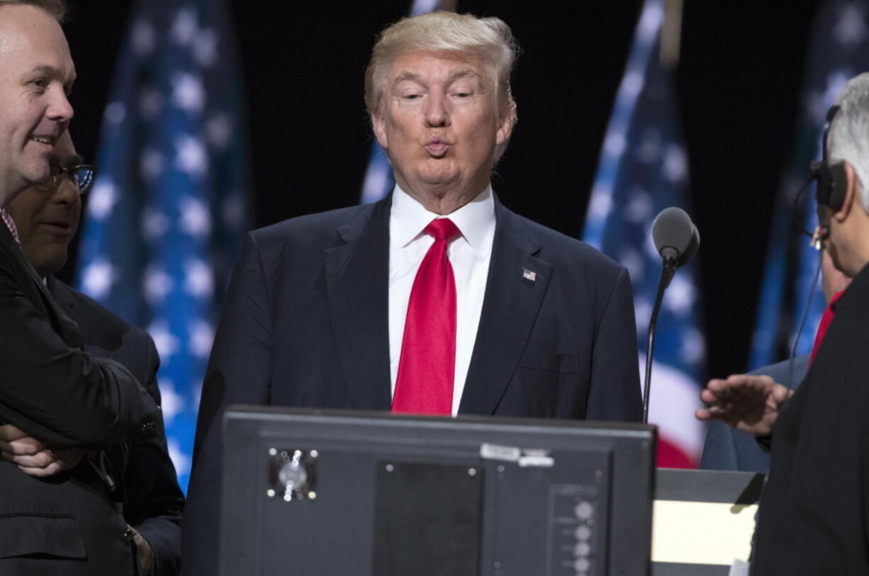 Republican presidential candidate Donald Trump, center, checks a video monitor as he talks with production crew during a walk through in preparation for his speech at the Republican National Convention, Thursday in Cleveland.