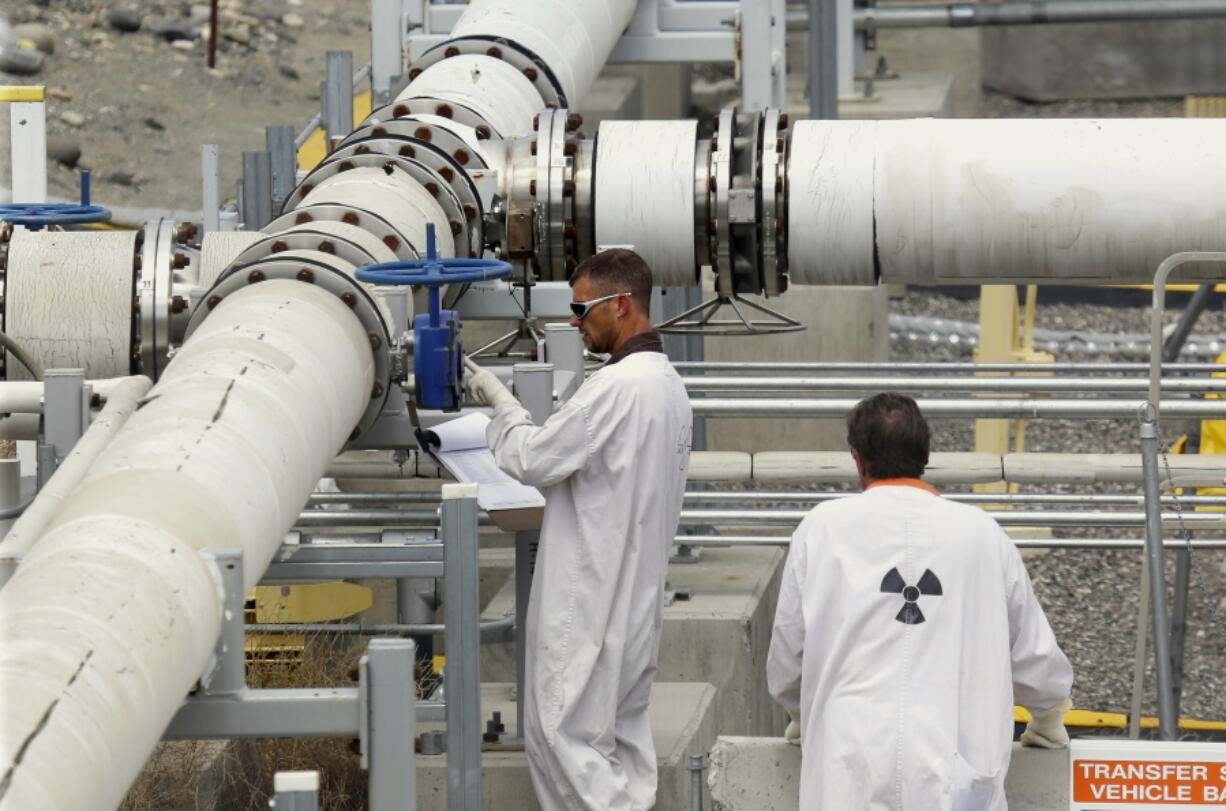 Workers wearing protective clothing and footwear inspect a valve at the &quot;C&quot; tank farm on the Hanford Nuclear Reservation near Richland. A coalition of labor unions on the Hanford Nuclear Reservation stopped work Monday at some of the radioactive waste tank farms because of health concerns over chemical vapors. The Hanford Atomic Metal Trades Council issued a &quot;stop work&quot; order at the double-walled tanks that contain dangerous wastes from the past production of plutonium for nuclear weapons.