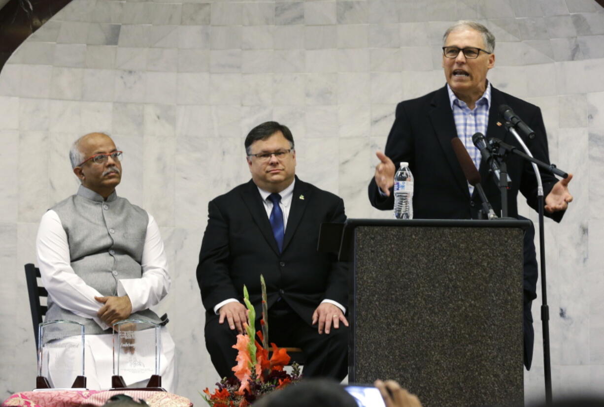 Gov. Jay Inslee, right, speaks Wednesday during a prayer service at the Muslim Association of Puget Sound Redmond Mosque in Redmond that marked the end of Ramadan and the start of Eid-al-Fitr. Seated are association president Mahmood Khadir, left, and Redmond Mayor John Marchione. (Ted S.