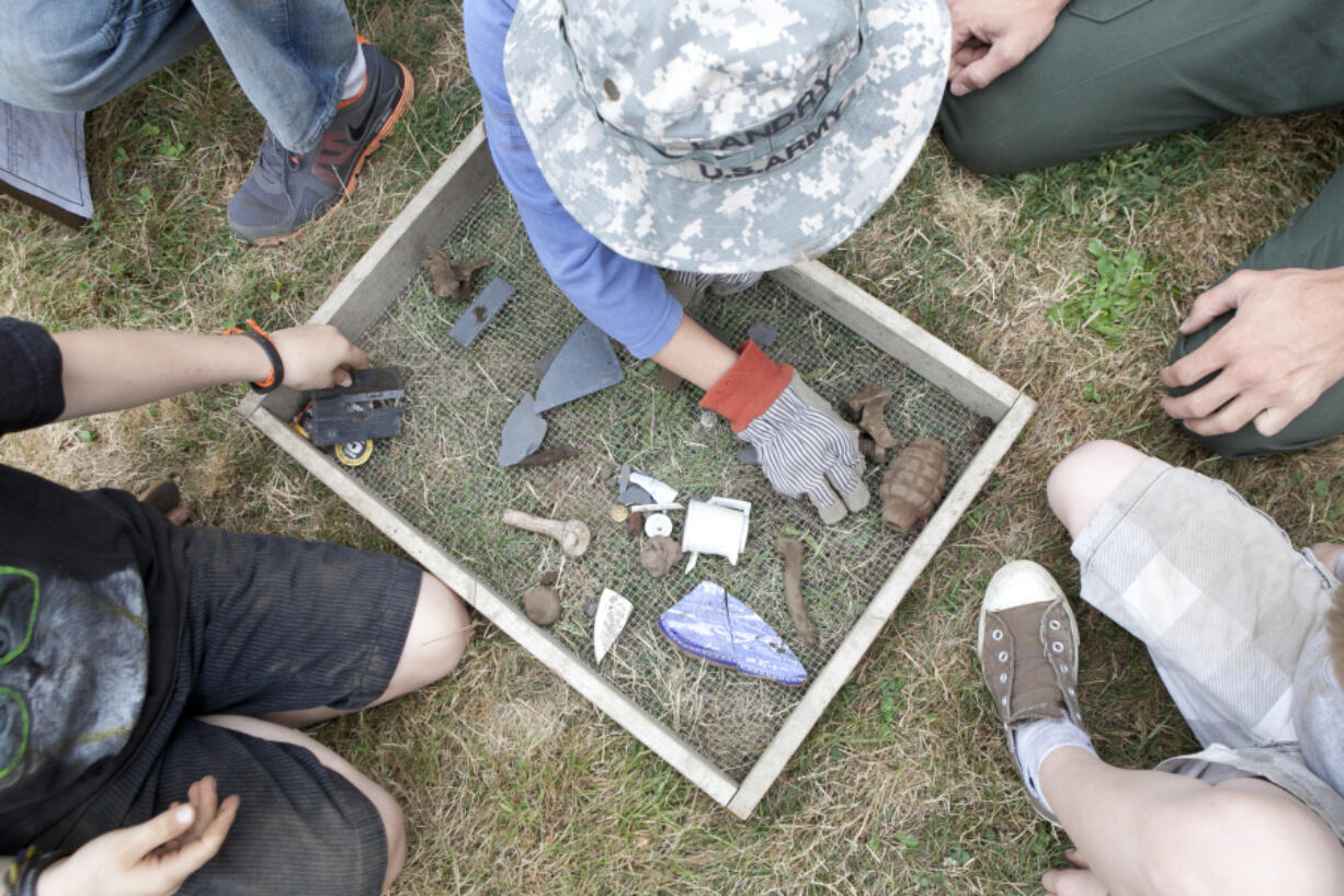 Kids take turns digging and sifting dirt at a mock archaeology dig at Fort Vancouver in August 2012.