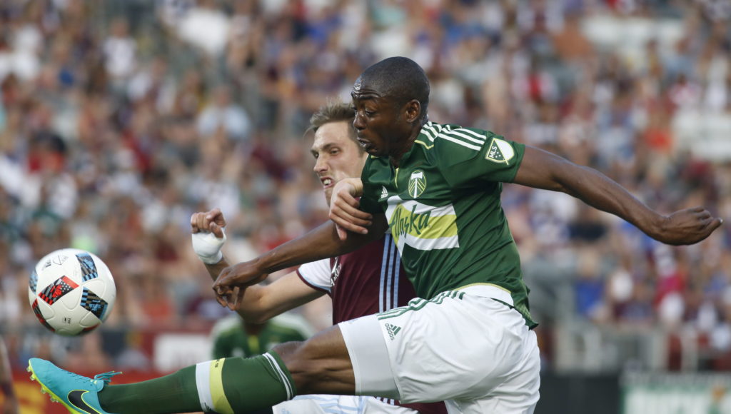 Portland Timbers forward Fanendo Adi, front, hooks a shot past Colorado Rapids defender Axel Sjoberg in the first half of an MLS soccer match Monday, July 4, 2016, in Commerce City, Colo.