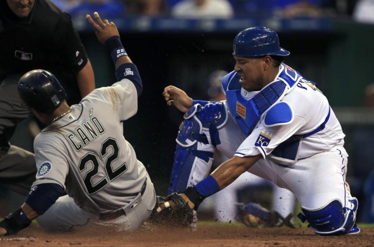 Seattle Mariners&#039; Robinson Cano (22) scores on an error by Kansas City Royals catcher Salvador Perez, right, during the sixth inning of a baseball game at Kauffman Stadium in Kansas City, Mo., Friday, July 8, 2016.