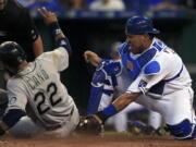 Seattle Mariners&#039; Robinson Cano (22) scores on an error by Kansas City Royals catcher Salvador Perez, right, during the sixth inning of a baseball game at Kauffman Stadium in Kansas City, Mo., Friday, July 8, 2016.