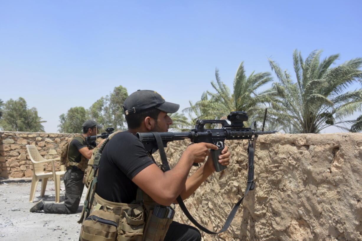 Iraqi soldiers scan the area during a military operation to regain control of villages north of Ramadi, 70 miles (115 kilometers) west of Baghdad, Iraq, Saturday, July 9, 2016. In the mostly Sunni province of Anbar, west of Baghdad, government troops on Saturday consolidated their grip on the provincial capital of Ramadi, retaken from the IS last year, when they captured two villages just north of the city.